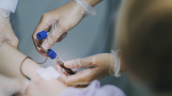 Medical professional taking a blood sample from a patient in a hospital setting