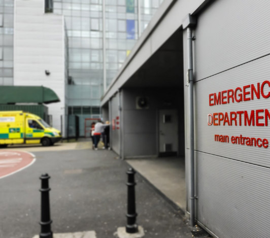 Why-is-it-needed Emergency department entrance with image of ambulance and 3 people in the background